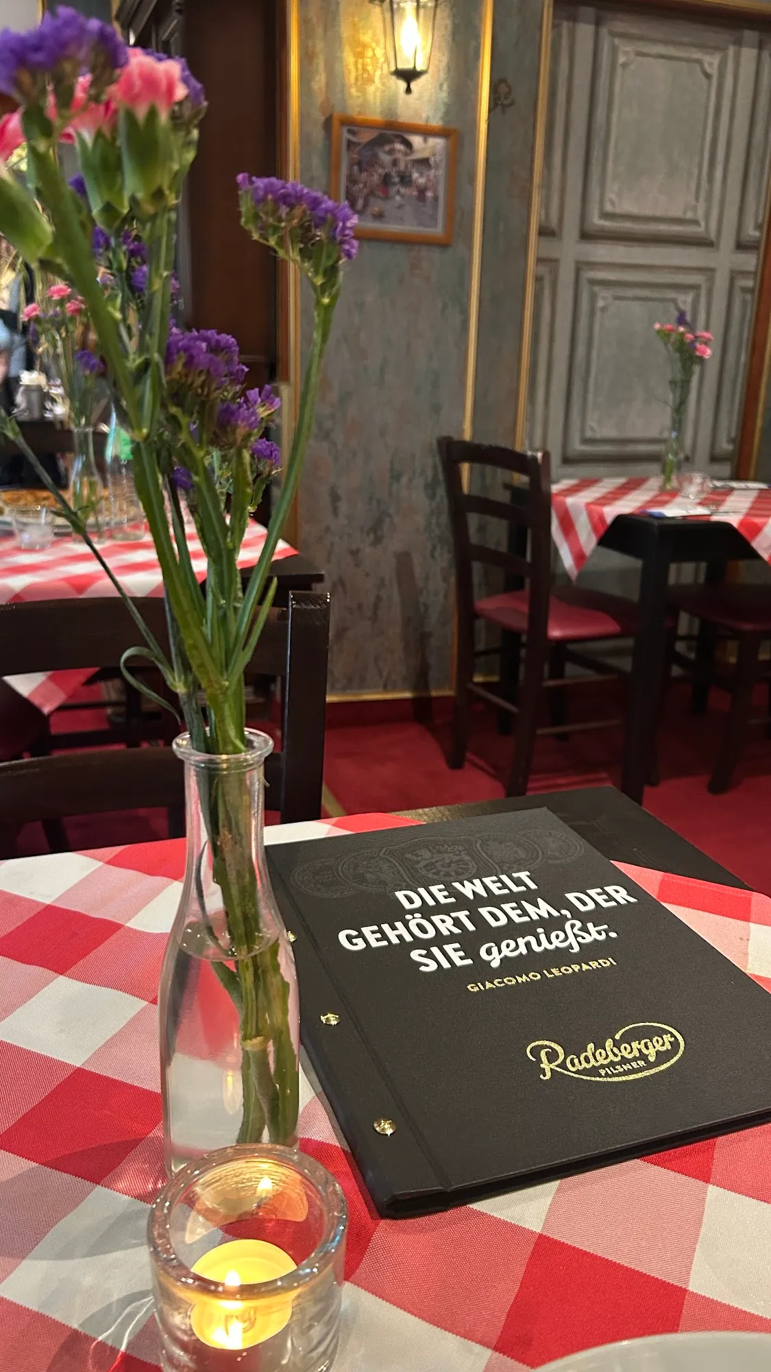 Gemütlich eingedeckter Tisch im Restaurant Lakcheri mit rot-weißer Tischdecke und Kerze